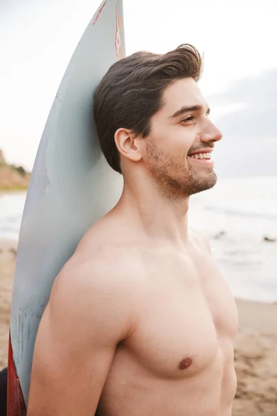 Bonito surfista homem com surf em uma praia fora . — Fotografia de Stock