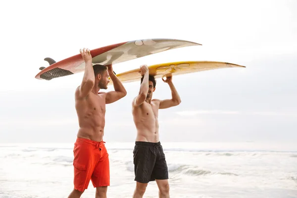 Двоє чоловіків-серферів друзі з серфінгом на пляжі зовні . — стокове фото