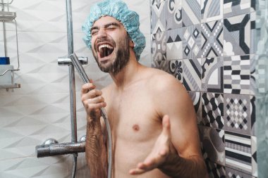 Çekici, genç, neşeli adam şarkı söylüyor.