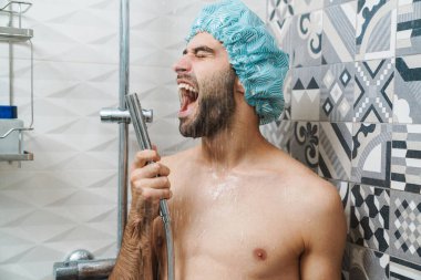 Çekici, genç, neşeli adam şarkı söylüyor.