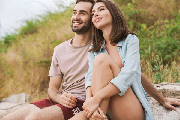 Foto de una hermosa pareja mirando hacia adelante y sonriendo mientras está sentada — Foto de Stock