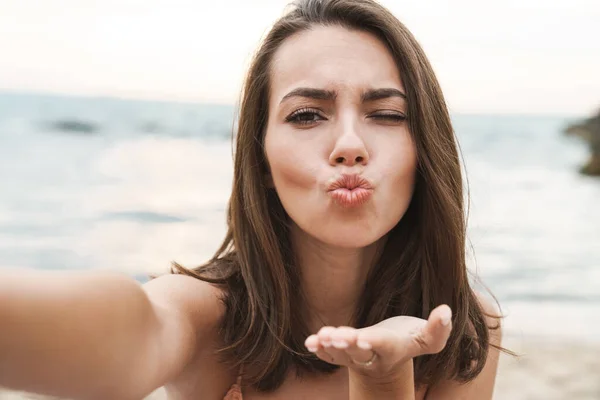 Imagen de una buena mujer enviando un beso de aire y tomando una foto selfie — Foto de Stock