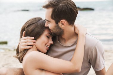 Romantik genç çiftin kucaklaşırken ve gülümserken fotoğrafı.