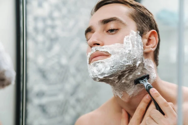 Attractive young shirtless man shaving — Stock Photo, Image