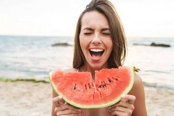 Beeld van aantrekkelijke verrukt vrouw eten watermeloen en schreeuwen — Stockfoto