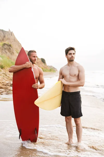 Positivo due surfisti uomini amici con surfings su una spiaggia — Foto Stock