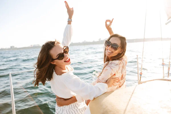 Hübsche Freundinnen im Freien auf einer Jacht im Meer. — Stockfoto