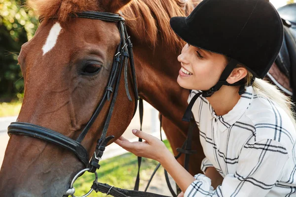 Imagem da mulher excitada usando chapéu de pé por cavalo no quintal em — Fotografia de Stock