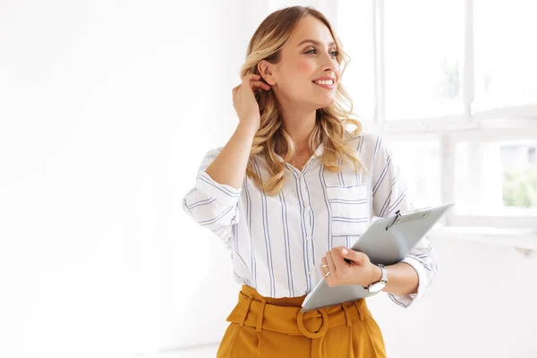 Imagen de hermosa secretaria mujer sujetando portapapeles en blanco de — Foto de Stock