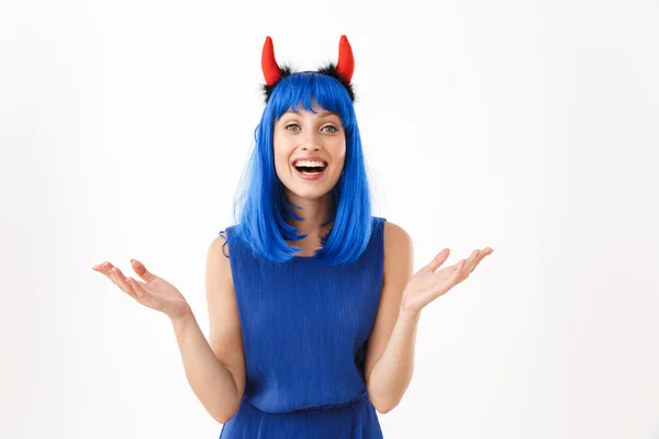 Retrato de bonito feliz mulher vestindo azul peruca e brinquedo diabo chifres sorrindo ao jogar as mãos — Fotografia de Stock