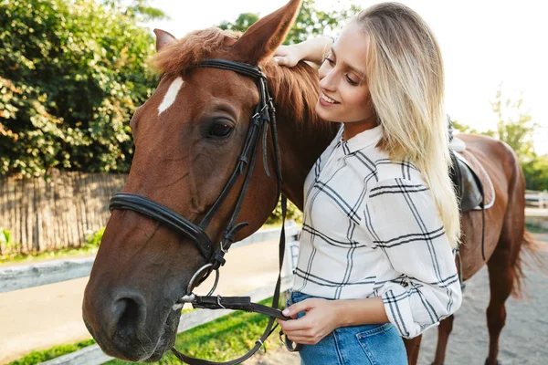 Imagen de la mujer sonriendo y de pie a caballo en el patio de los países —  Fotos de Stock