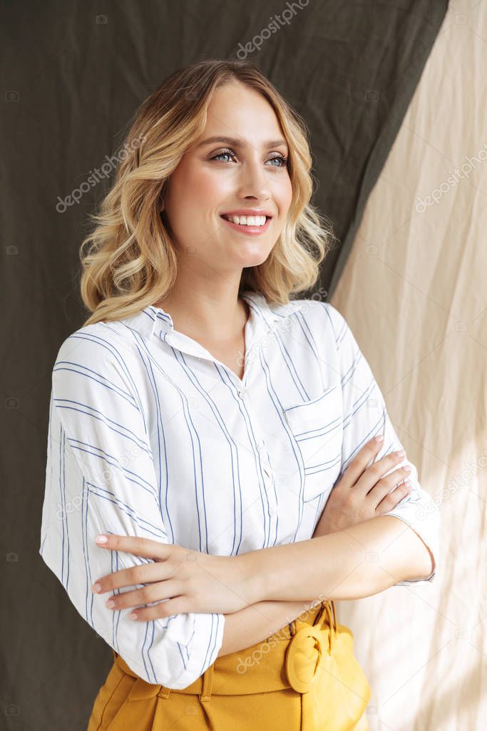 Image of attractive elegant blonde woman standing with arms cros