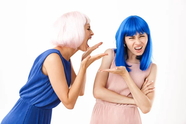 怒气冲冲的女人戴着粉色假发对着拿着版权的困惑女孩尖叫的画像 — 图库照片