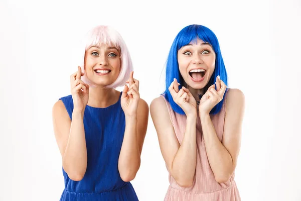 Porträt zweier aufgeregter, glücklicher Frauen mit blauen und rosa Perücken, die zum Glück die Daumen drücken — Stockfoto