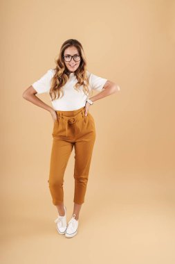 Moda kadını gülümseyen ve kameraya bakan uzun bir görüntü.
