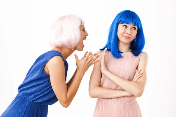 Potret wanita marah mengenakan wig merah muda sambil memegang teriakan pada gadis bingung yang menunjukkan sikap berhenti — Stok Foto
