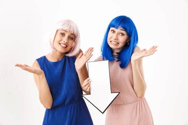 Kafası karışmış iki kadının portresi mavi ve pembe peruklar takıyor ve ellerinde boş bir oklu ok işareti var. — Stok fotoğraf
