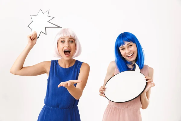 Portret van twee opgewonden lachende vrouwen met blauwe en roze pruiken met lege plakkaatjes als tekst voor copyspace — Stockfoto