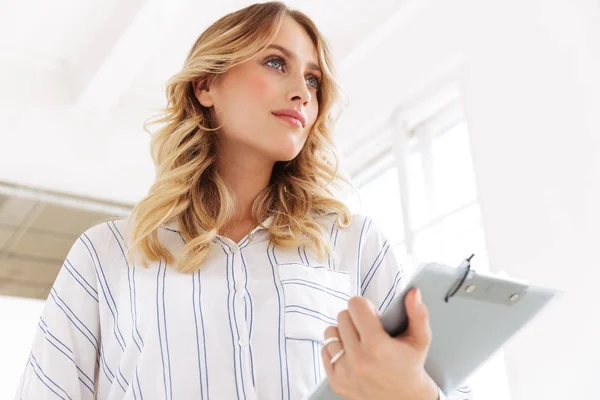 Bild der verführerischen eleganten Geschäftsfrau mit Klemmbrett in der Hand — Stockfoto