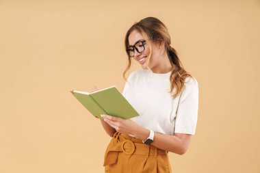 Çekici bir kadının gülümsemesi ve günlük defterine notlar yazması
