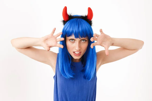Retrato de jovem mulher agressiva vestindo peruca azul e chifres de brinquedo jogando papel de diabo — Fotografia de Stock