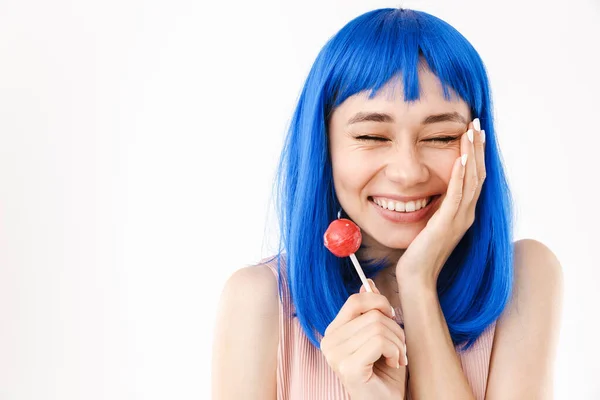 Retrato de primer plano de una bonita mujer sonriente con peluca azul sosteniendo piruleta y riendo —  Fotos de Stock