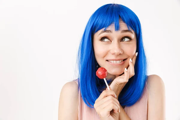 Retrato de una bonita mujer sonriente con peluca azul sosteniendo piruleta y mirando a un lado al espacio de copyspace —  Fotos de Stock