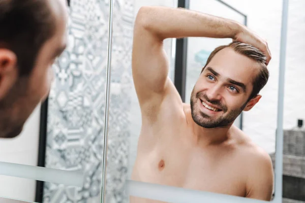 Mutlu, genç, üstsüz adam banyoda kendine bakıyor. — Stok fotoğraf
