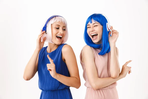 Mavi ve pembe peruklu iki kadının portresi kulaklık kullanırken parmaklarını kenarda gösteriyor. — Stok fotoğraf