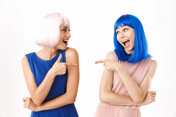Ritratto di due donne deliziate che indossano parrucche blu e rosa puntando il dito contro l'altro — Foto Stock