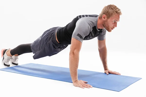 Confident attractive sportsman doing plank exercise — Stock Photo, Image