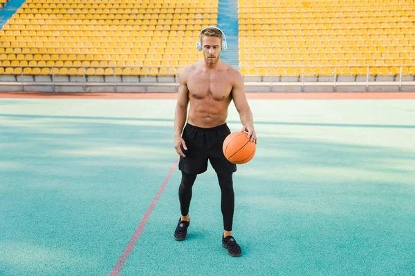 Imagem do jovem em fones de ouvido jogando basquete em esportes st — Fotografia de Stock