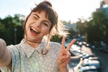 Balkonda mutlu ve güzel bir kadın. Huzuru gösteren bir selfie çek..