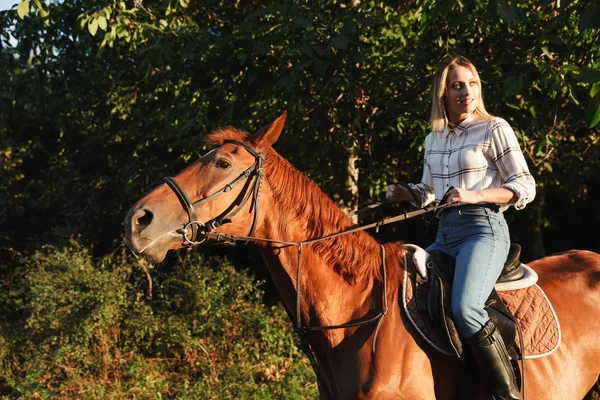 Immagine di una giovane bionda che sorride e cavalca in campagna — Foto Stock