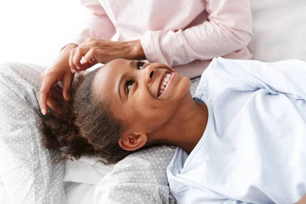 Imagem da jovem mulher e sua filha afro-americana no sofá — Fotografia de Stock