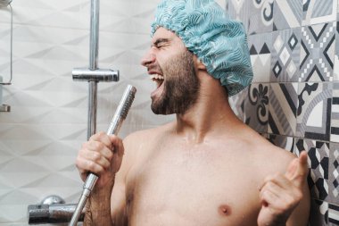 Çekici, genç, neşeli adam şarkı söylüyor.