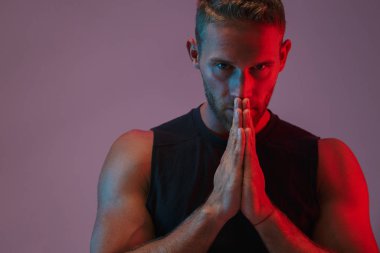 Neon ışıklarının üzerinde izole bir şekilde poz veren sporcu.