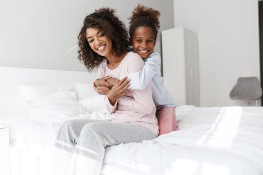 Afro-Amerikan kadın ve küçük kızının kucaklaşması. 