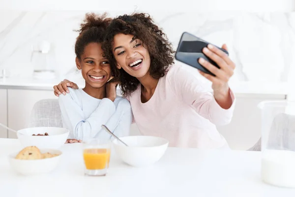 Image de la femme américaine et sa fille en utilisant un téléphone portable pendant h — Photo