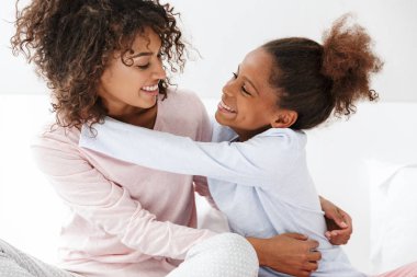 Afro-Amerikan kadın ve küçük kızının kucaklaşması. 