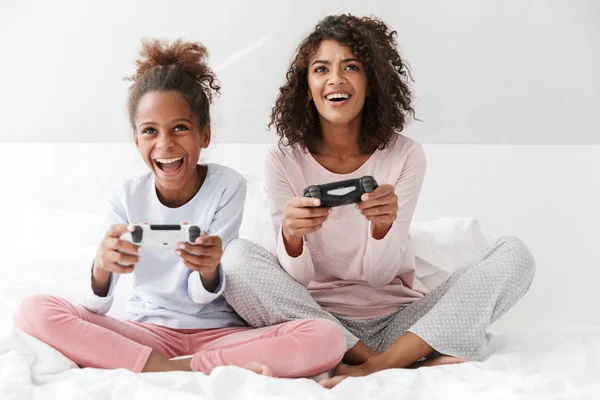 Imagen de mujer americana y niña jugando videojuegos con —  Fotos de Stock