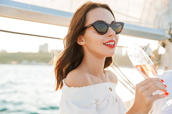 Positive Frau im Freien im Meer Champagner trinkt. — Stockfoto