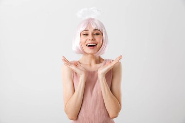 Pembe peruk ve oyuncak haleler takmış, elleri kusarken kameraya bakan güzel bir kadının portresi.