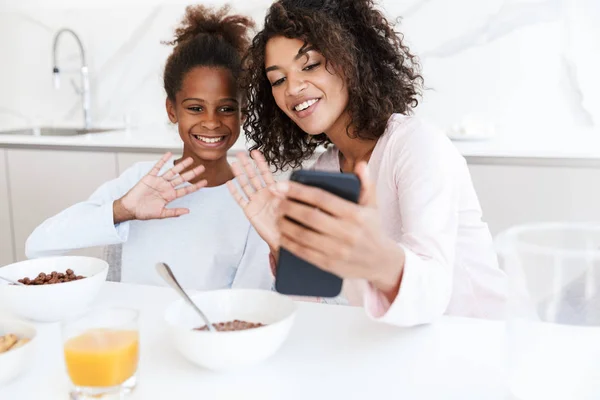 Obraz amerykańskiej kobiety i jej córki korzystających z telefonu komórkowego podczas h — Zdjęcie stockowe