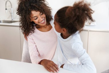 Afro-Amerikan kadın ve küçük kızının kucaklaşması. 