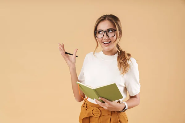 Immagine di una giovane donna che sorride e annota nel diario — Foto Stock