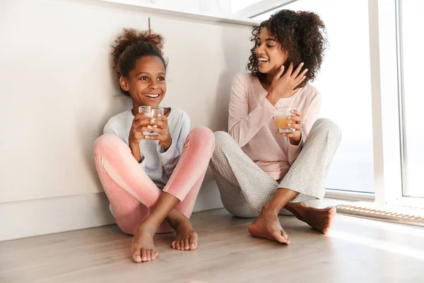 Souriant jeune mère et sa petite fille en pyjama — Photo