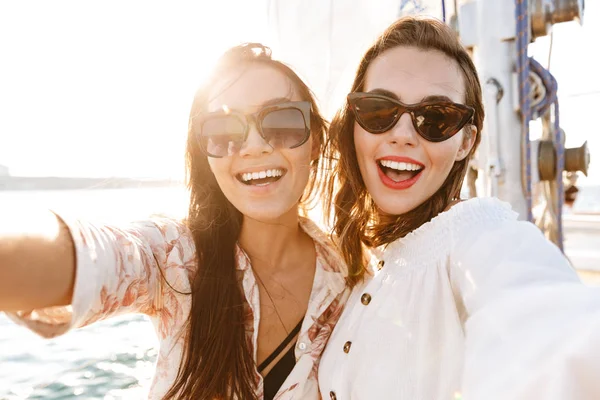 Freundinnen draußen auf Jacht im Meer machen ein Selfie — Stockfoto
