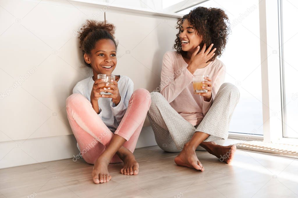 Smiling young mother and her little daughter wearing pajamas