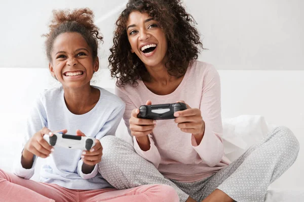 Imagen de mujer americana y niña jugando videojuegos con —  Fotos de Stock